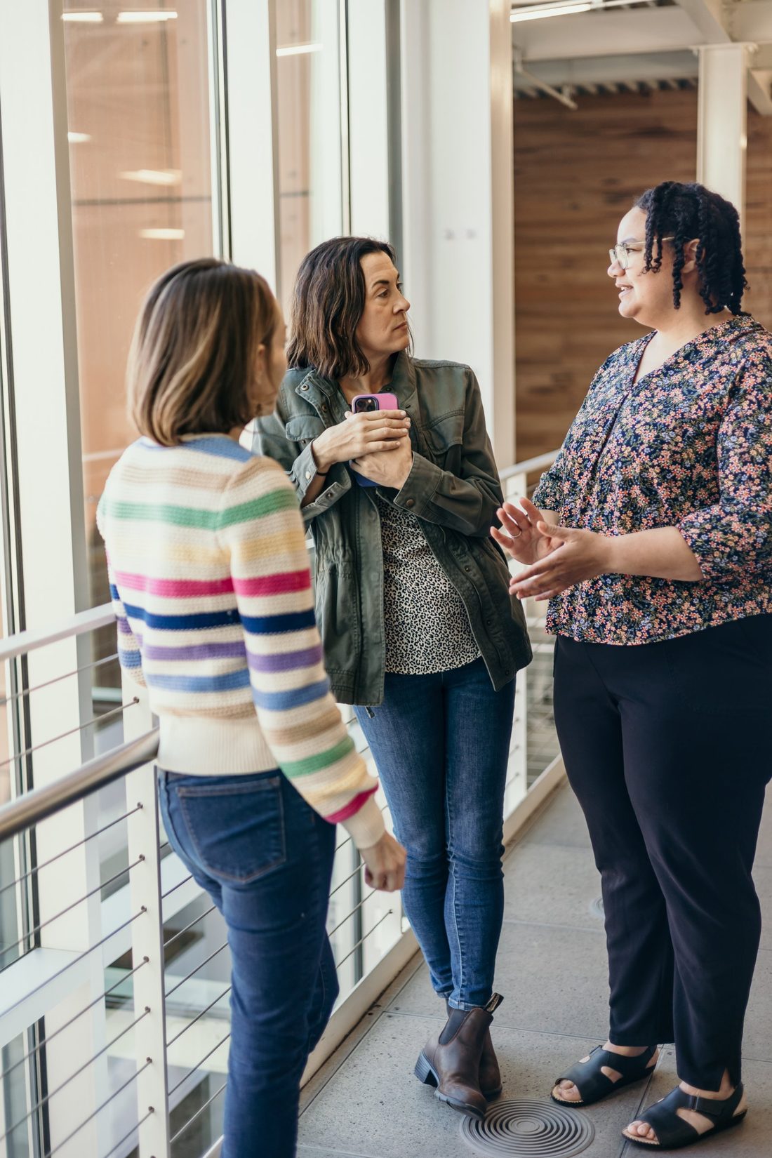 Rachel talking with two women by a bright window