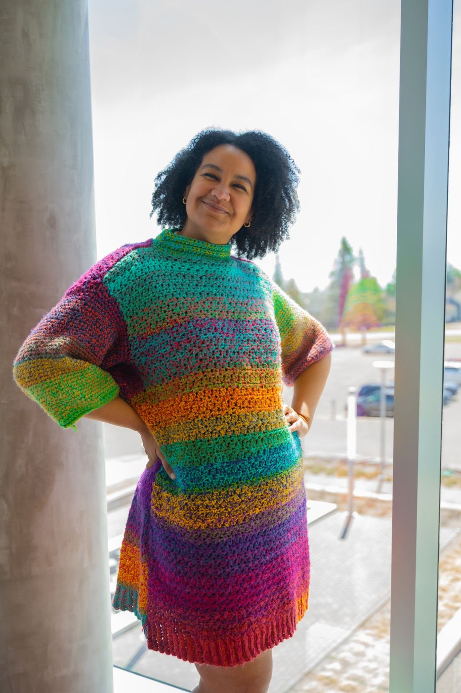Rachel wearing a colorful sweater she crocheted herself